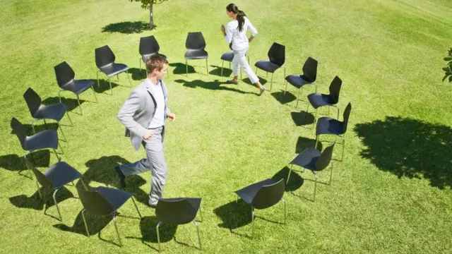 Dos personas dando vueltas en el "juego de las sillas musicales"