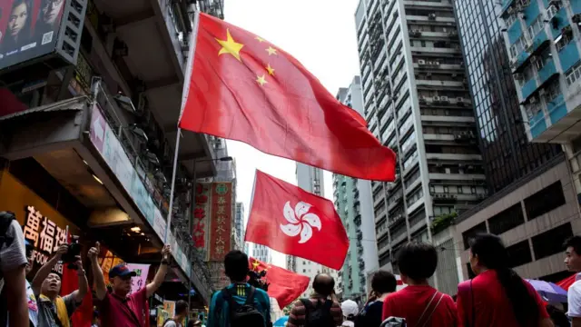 Manifestantes proChina ondean las banderas de China y de Hong Kong durante un mitin progubernamental en esa isla.