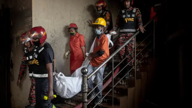 দমকল বাহিনীর সদস্যরা মরদেহ নামিয়ে আনছেন।
