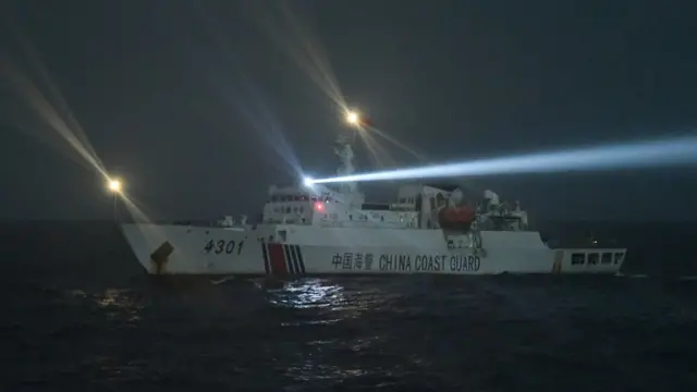 Kapal Coast Guard China-4301 membayangi KRI Usman Harun-359 dengan menggunakan lampu sorot ke anjungan saat melaksanakan patroli mendekati kapal nelayan pukat China yang melakukan penangkapan ikan di ZEE Indonesia Utara Pulau Natuna, Sabtu (11/1/2020) dini hari.