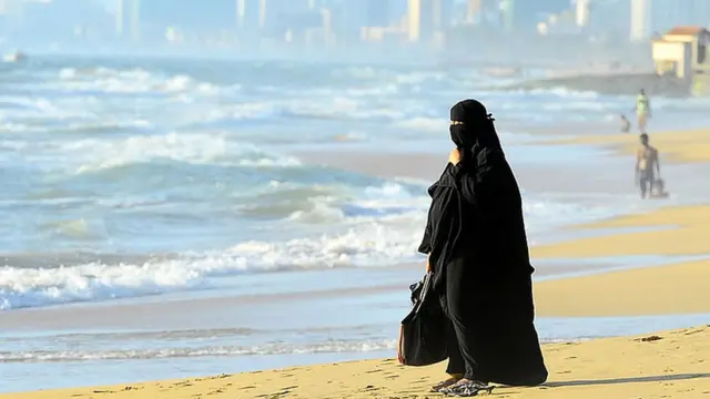 إمرأة منقبة على شاطئ البحر