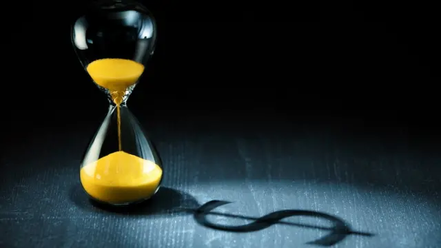 Reloj de arena y signo de dólares