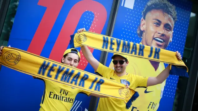 Aficionados frente a un poster publicitario de Neymar