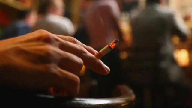 Человек курит в Doors Music Pub в Берлине, Германия, 2008 год.