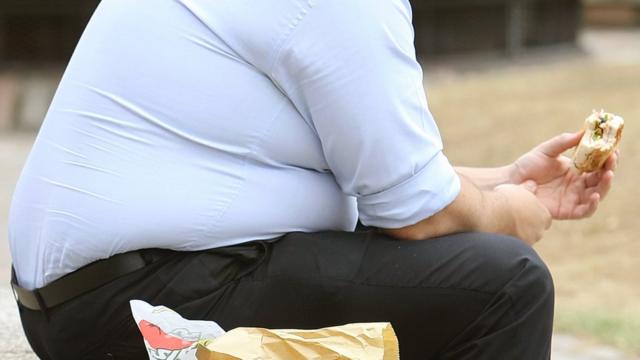 Homem comendo sanduíche