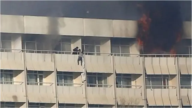 ඉහළ මහලේ සිටි නේවාසිකයන් ඇඳ ඇතිරිලි යොදා ගනිමින් කවුළුවලින් පිටතට එන ආකාරය