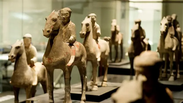 Hombres a caballo dentro de una exhibición sobre el Ejército de Terracota