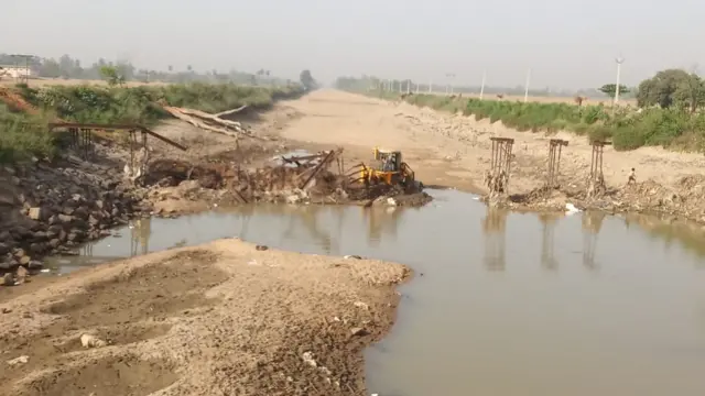 The earth excavator dismantling the bridge