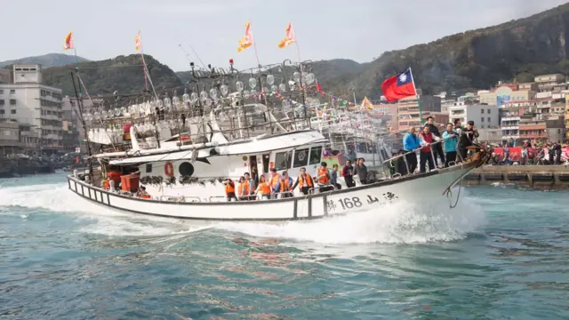 YEHLIOU, TAIPEI, TAIWAN - 2016/02/22: Squid boats from a harbour fishing fleet let off fireworks as they circle the harbour opposite the Bao-an Temple in a harbour cleansing ritual. Each boat carries an icon of the gods and passing in front of the temple acts as the first stage of the blessing ceremony. Later, participants will jump into the sea with the icons, and finally take them firewalking to conclude the annual ritual. (Photo by Craig Ferguson/LightRocket via Getty Images)