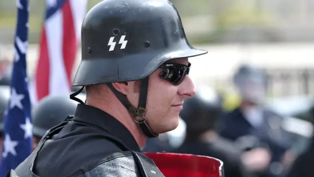 Homem usando capacete com símbolos nazistas