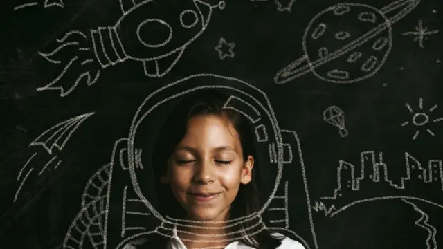 Мечтательная девочка в окружении изображений на тему покорения космоса