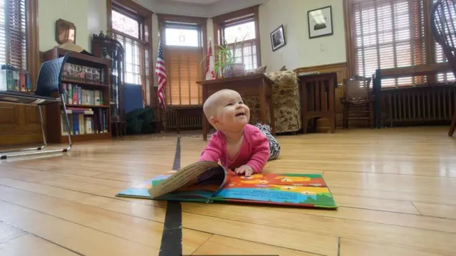 طفل رضيع يصوره أهله بجوار الخط الحدودي في مكتبة هاسكل