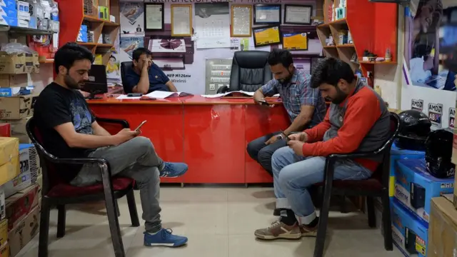 मोबाइल इस्तेमाल करते नौजवान