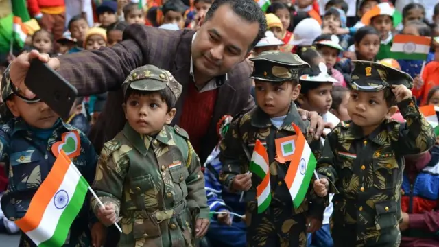 બાળકો સાથે સેલ્ફી લેતી એક વ્યક્તિ