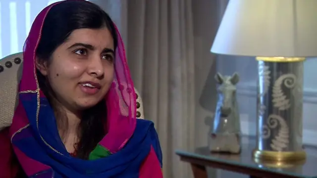 Com véu, Malala sorri enquanto falaaposta final da copaentrevista