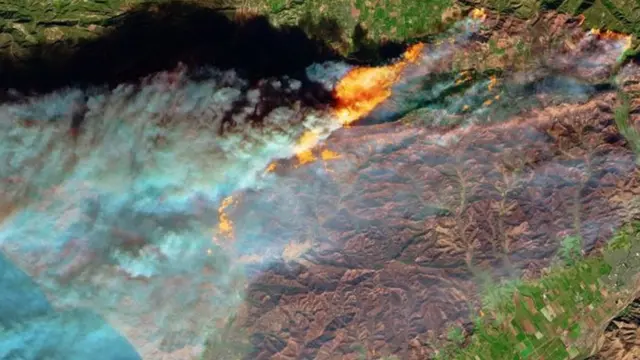 Sawirro Satellite lagu qaaday oo muujinaya dabka oo baabi'iyey waqooyiga Los Angeles, kuna faafay dhinaca badda Pacific.