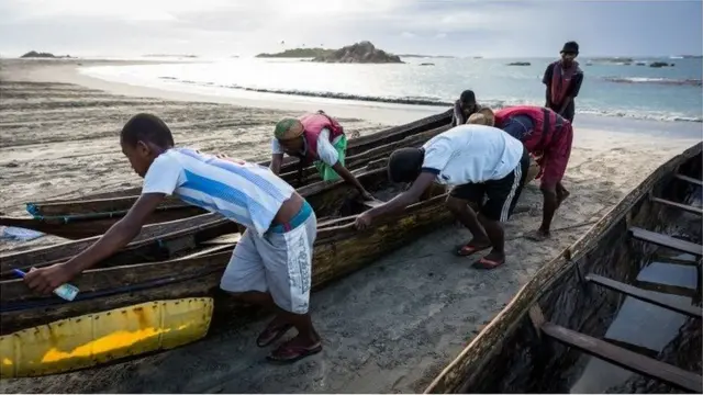 Hauling rickety wooden boats in with plastic sheet repairs
