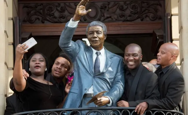 Waa dad sawir la galaya taalada loo sameeyay madaxweynihii hore ee Koonfr Afrika Nelson Mandela oo ku taalla magaalada Cape Town.