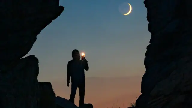 Silhueta de homem observando Lua