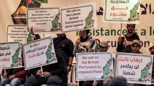 رجال يرفعون لافتات تصور خريطة لفلسطين التاريخية ملفوفة بالأعلام الفلسطينية، ويحثون البرلمان البريطاني على عزل وزيرة الداخلية بريتي باتيل، خلال تجمع للفصائل الفلسطينية ضد تصنيف بريطانيا المحتمل لحركة حماس. منظمة إرهابية في 23 نوفمبر /تشرين الثاني 2021