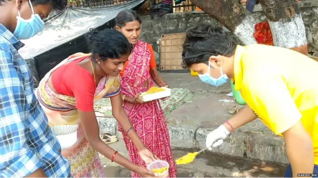 पत्रकार मनिष झा बेघरांना अन्न वाटप करताना