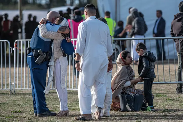 افسر پلیس نیوزیلند، خانواده یکی از داغداران کرایست چرچ را در آغوش گرفته و دلداری می‌دهد