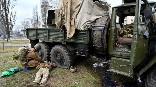 Nhân viên quân y Ukraine khám nghiệm thi thể của một quân nhân Nga mặc quân phục Ukraine sau khi anh ta và các thành viên của một nhóm đột kích bị bắn trong một cuộc giao tranh ở thủ đô Kyiv hôm 25/2.