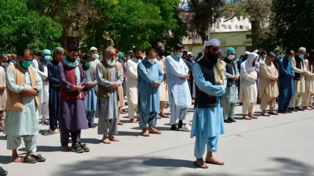 Masu ba da agajin gaggawa a Pakistan da wasu mutane na wa wani abokin aikinsu sallar gawa daga nesa wanda ya mutu dalilin korona a ranar 25 da wtaan Afrilun 2020