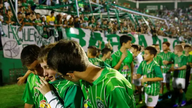 Crianças abraçadas chorando na Arena Condá