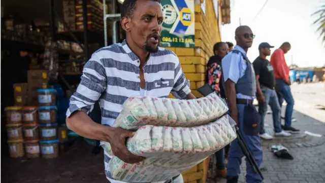 Wani bako yana dauke kayansa daga wani shago da aka fasa a Johannesburg ranar 3 ga watan Satumbar, 2019