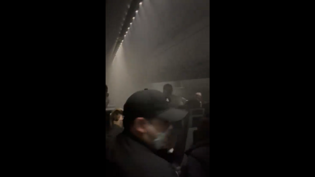 煙が充満する機内から脱出しようとする乗客