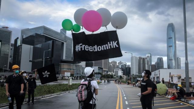 香港示威者升起写有“FreedomHK”的黑色旗帜
