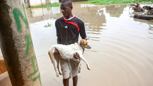 Wani mutum dauke da karensa a wata ambaliyar ruwa a babban birnin Angola wato Luanda ranar Juma'a.