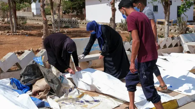 People look at the dead bodies outside the hospital, after a powerful storm and heavy rainfall hit Libya, in Derna, Libya on 12 September, 2023
