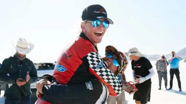 Shea Holbrook y Denise Mueller Korenek se abrazan en el salar de Bonneville, Utah.