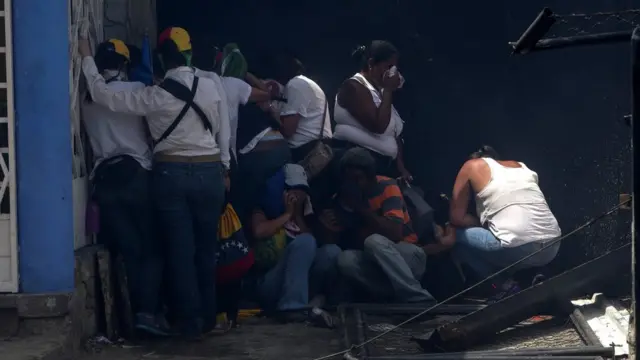 Manifestantes se protegen de los gases