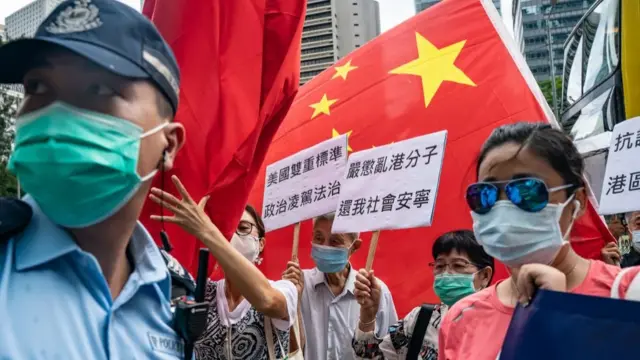 6月26日,北京支持者在美国驻香港总领事馆高举中国国旗和标语牌。