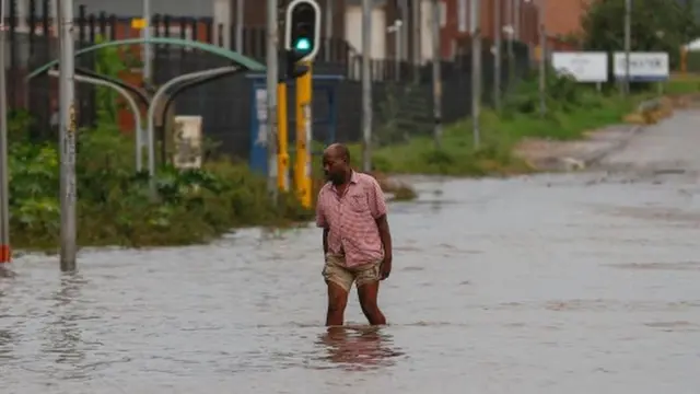Un hombre camina en una calle inundada