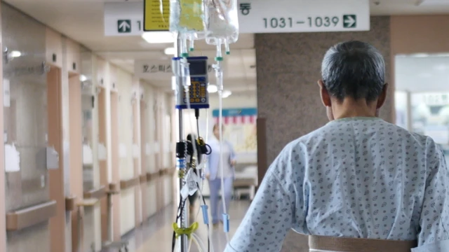 환자가 링게를 단 채 병원 복도를 걷고 있다.
