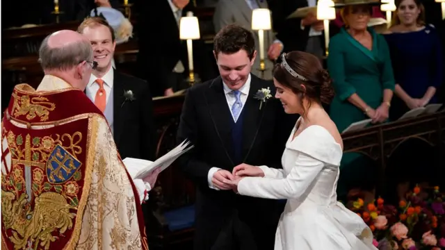 Princess Eugenie smiles as Jack Brooksbank put the ring on her finger during their wedding ceremony at St George"s Chapel