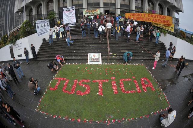 Familiares de las víctimas de la masacre de Dos Erres, en Petén, Guatemala, escribieron "justicia" con pétalos de flores a la entrada de la Corte Suprema de Justicia durante el juicio por el caso el 2 de agosto de 2011.