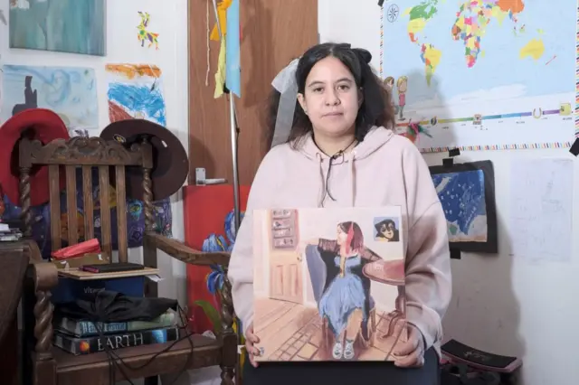Rebecca com um retrato pintado para ela por uma das pessoas que ela gosta