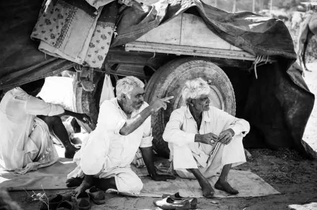 رجال يجلسون إلى جانب شاحنة