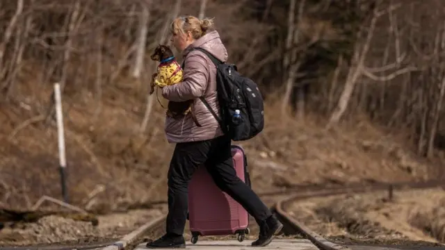 ये शरणार्थी महिला अपने कुत्ते को साथ ले जा रही है