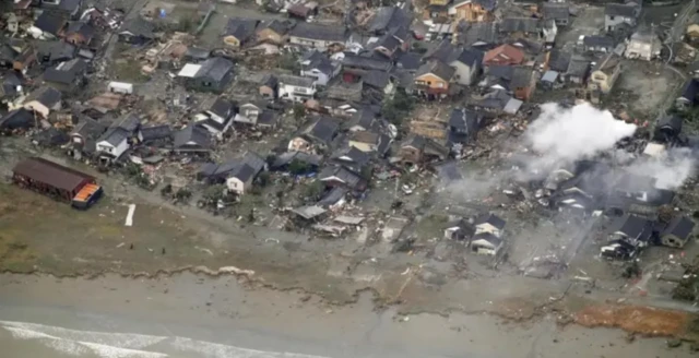 Imagem aérea de dano causado em área residencial por tsunami
