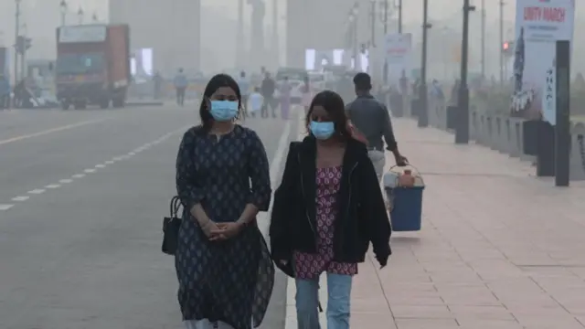 मास्क लगाएका दुई युवती सडकमा हिँड्दै