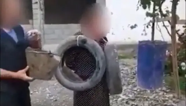 Соцжелелерге тараган Сузак районунда аялынын мойнуна дөңгөлөк илип кордогон эркектин видеосунан кадр.