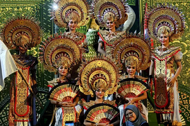 Para wanita Bali berpose sebelum melakukan ritual tradisional pelepasan matahari tahun 2025 dan penyambutan matahari tahun 2026, selama perayaan Malam Tahun Baru di Denpasar, pulau resor Bali, Indonesia, pada 31 Desember 2025. 