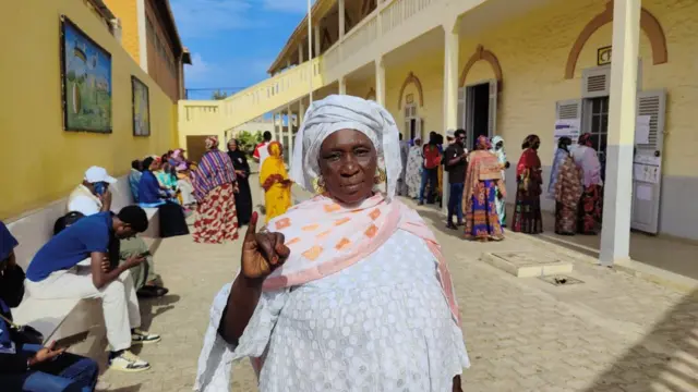 Cette électrice est fière de montrer son doigt imbibé d'encre indélibile, signe qu'elle a voté. 