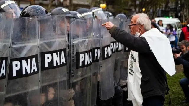 Aposentado protesta em frente a uma barreira de policiais argentinos